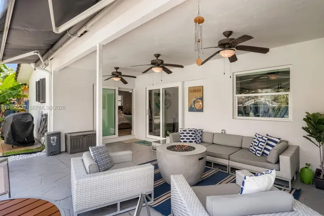 a living room with patio furniture and a floor to ceiling window