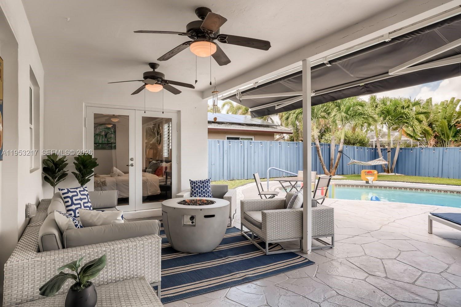 5117 Cleveland Street Hollywood, FL 33021 - Photo 32 of 39 a living room with patio furniture and a floor to ceiling window