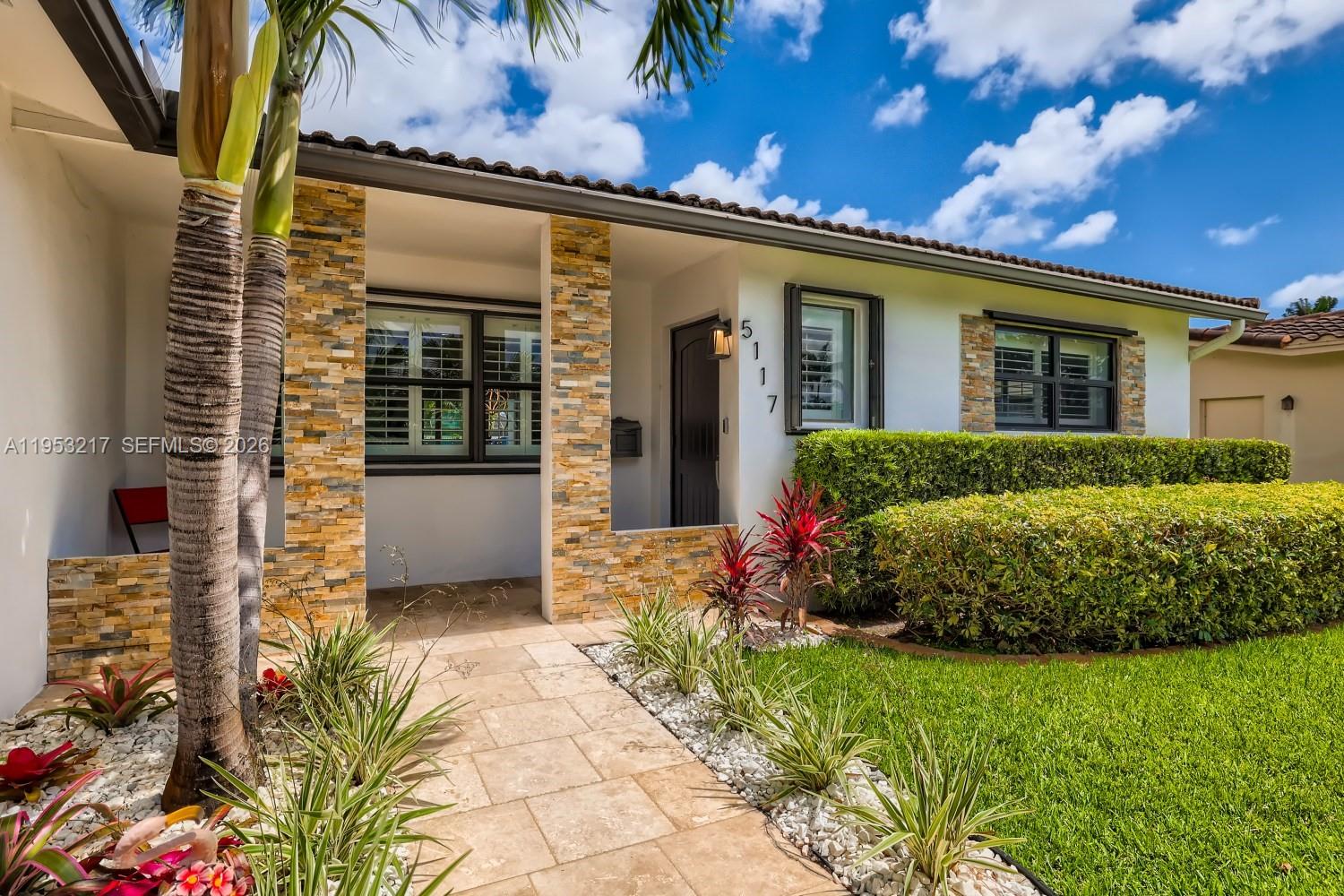 5117 Cleveland Street Hollywood, FL 33021 - Photo 4 of 39 a front view of a house with a garden