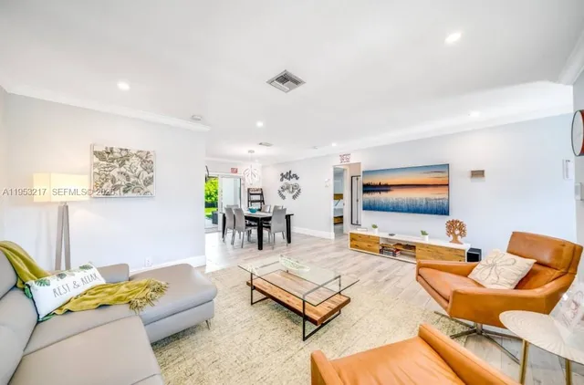 a living room with furniture a wooden floor and a large window