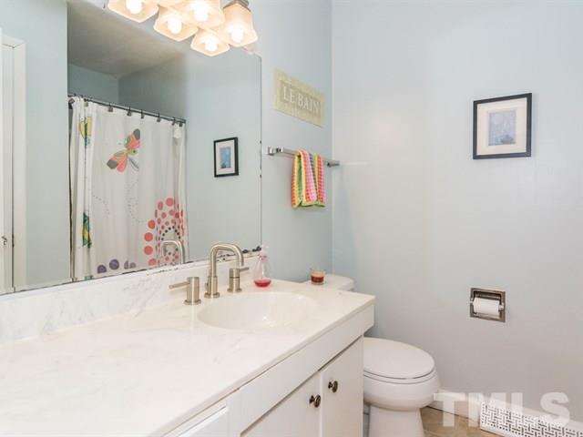 1726 Euclid Road Durham, NC 27713 - Photo 17 of 25 a bathroom with a sink vanity mirror and toilet