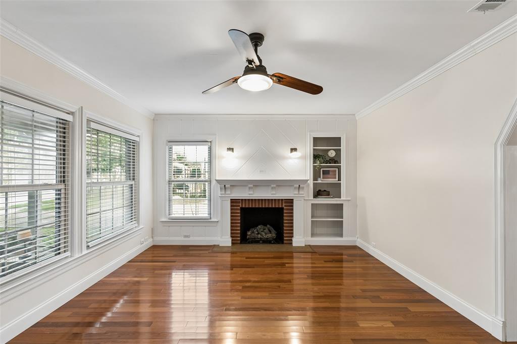2427 Alco Avenue Dallas, TX 75211 - Photo 9 of 26 a view of an empty room with wooden floor fireplace and a window