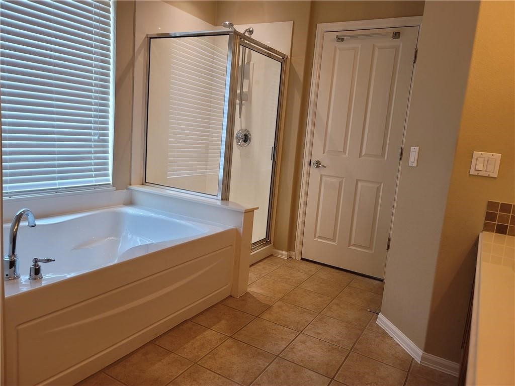 208 Hummingbird Lane Leander, TX 78641 - Photo 13 of 25 Relax in the deep soaking tub or refresh in the sleek glass-enclosed shower.