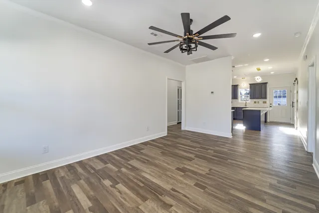a view of empty room with wooden floor and window