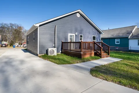 a view of a house with a yard and fence