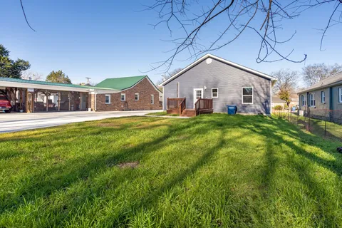a front view of a house with a yard and trees