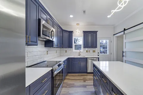 a kitchen with stainless steel appliances granite countertop a sink stove and refrigerator