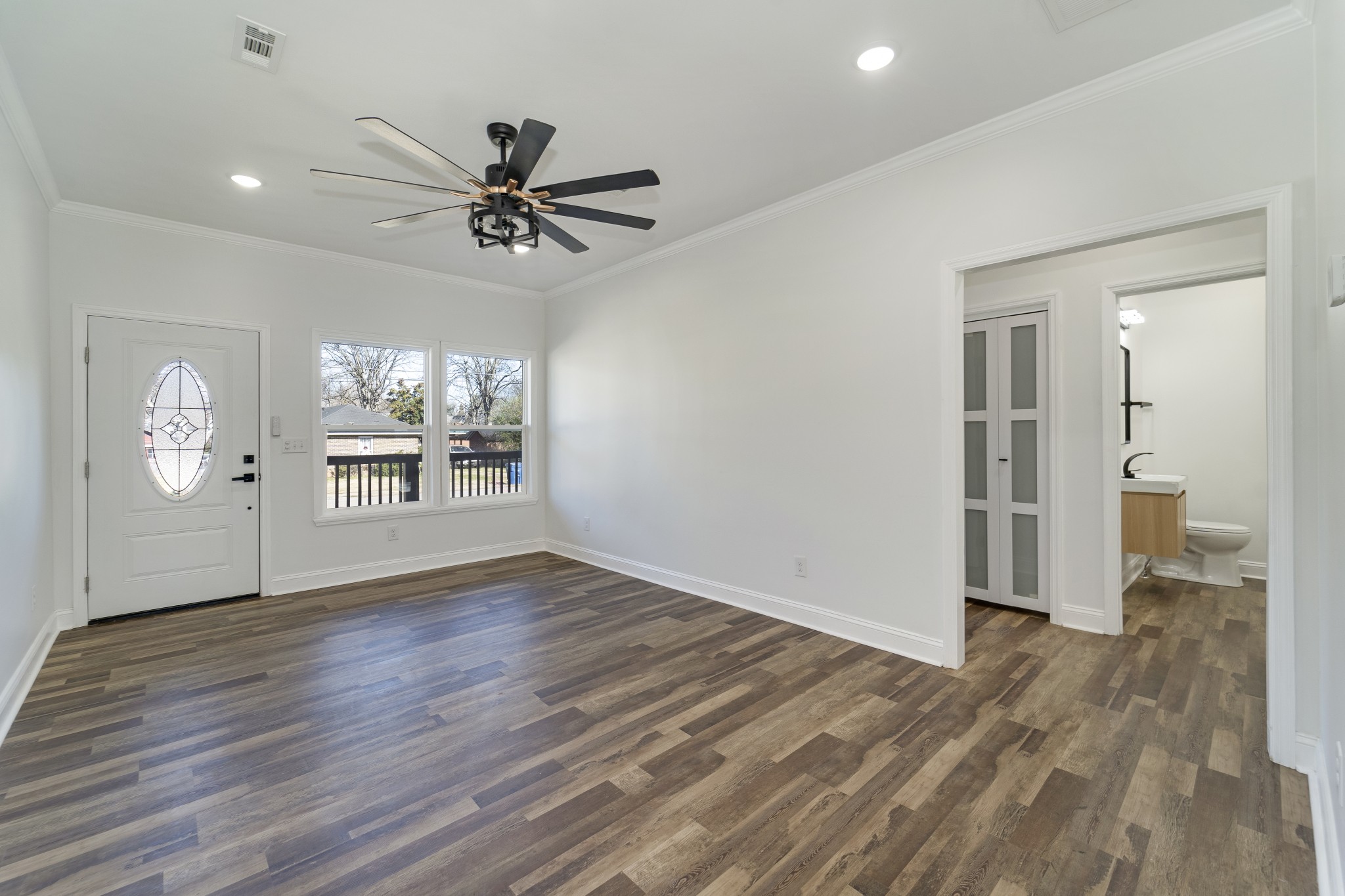 307 Wall Street Mount Pleasant, TN 38474 - Photo 10 of 33 an empty room with wooden floor a ceiling fan and windows