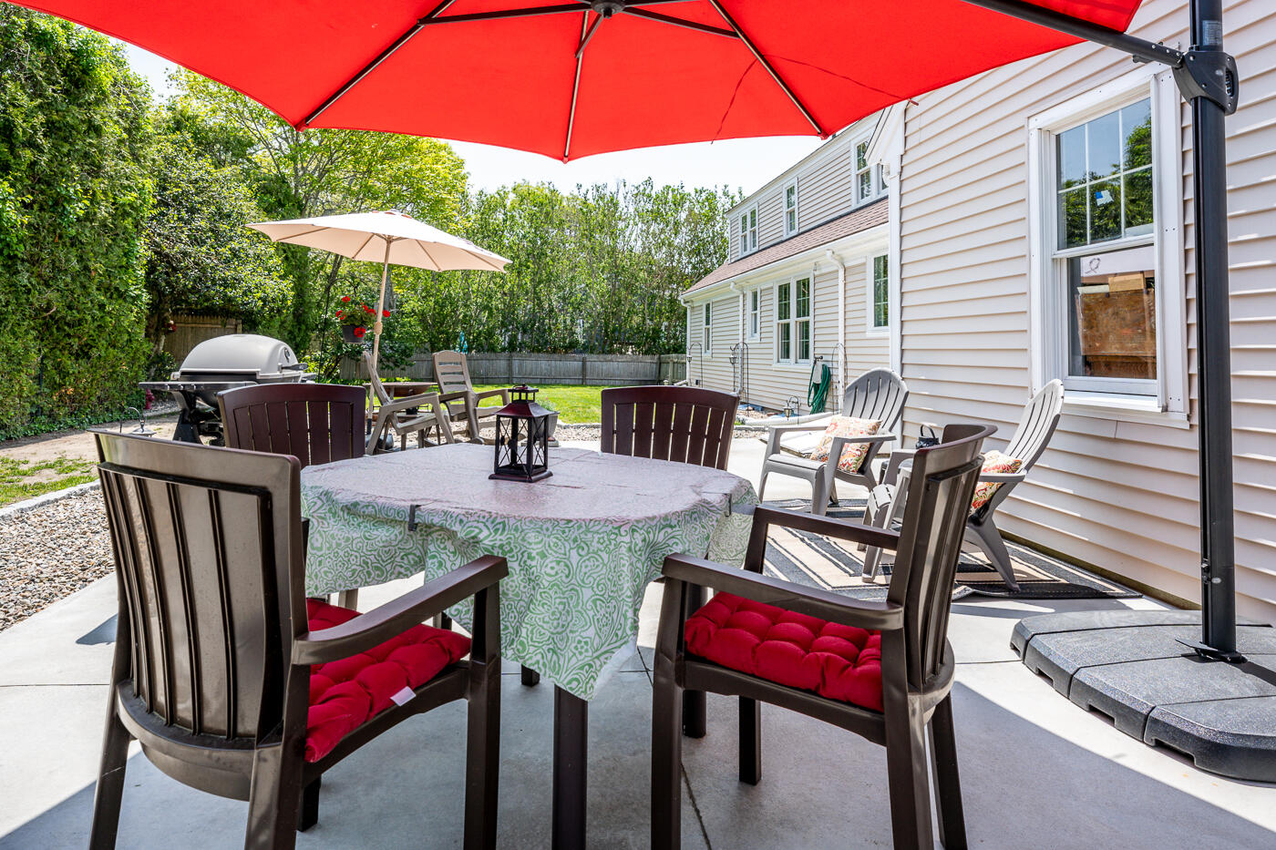 110 Bacon Road Hyannis, MA 02601 - Photo 30 of 37 a view of a patio with a dining table and chairs under an umbrella