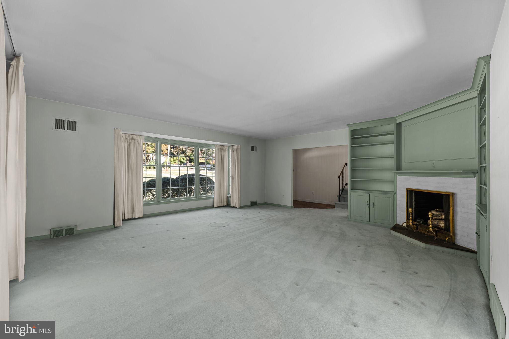 962 Weadley Road Radnor, PA 19087 - Photo 6 of 45 an empty room with a fireplace and window