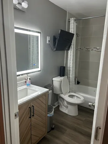 a bathroom with a sink a toilet and shower