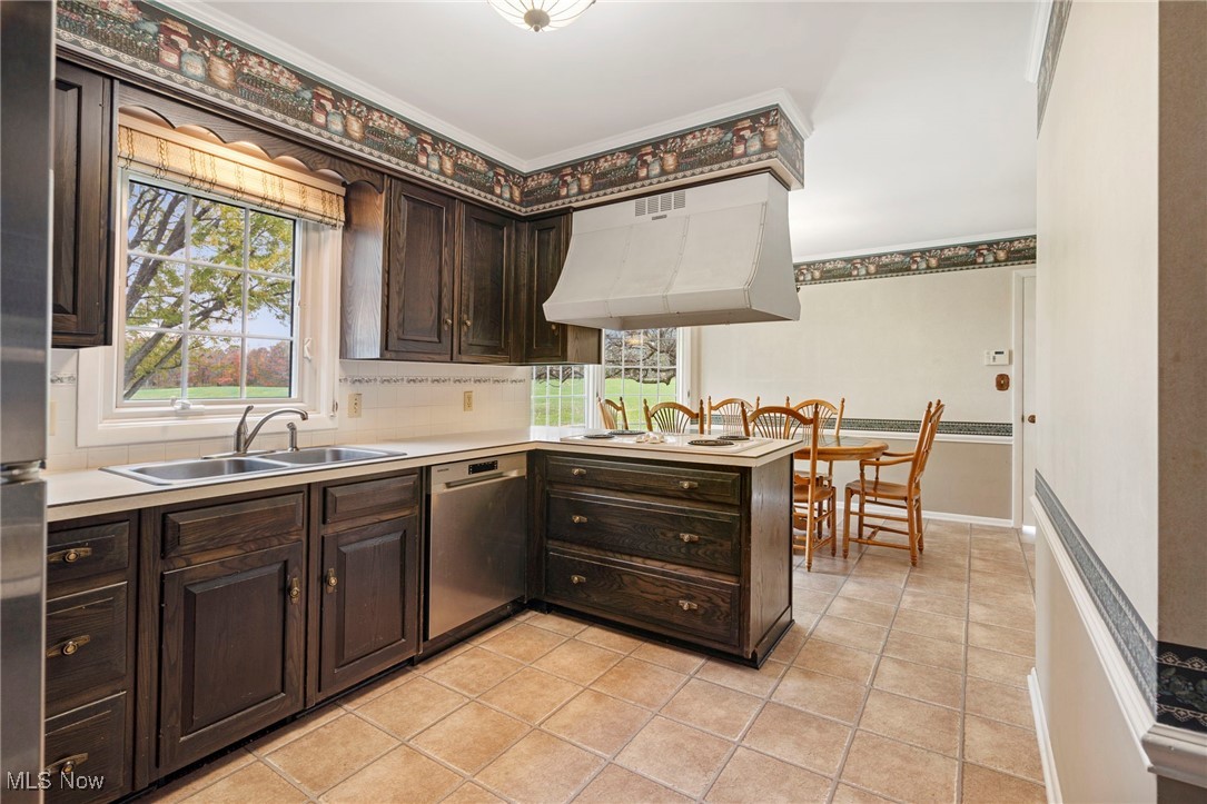 14265 Reeder Avenue Northeast Alliance, OH 44601 - Photo 20 of 39 Kitchen with dark brown cabinets, light countertops, a peninsula, light tile patterned flooring, and under cabinet range hood