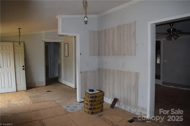 en empty room with windows and ceiling fan