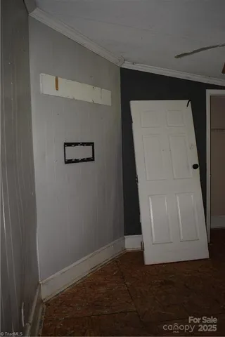 an empty room with wooden floor door and windows