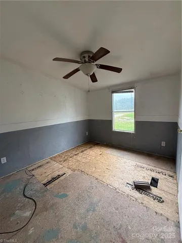 a living room with furniture and a ceiling fan