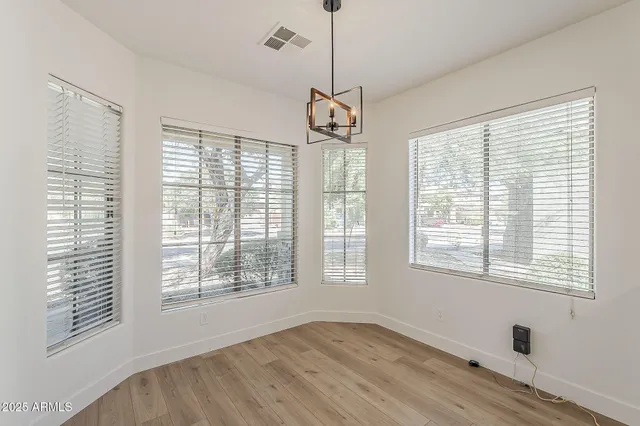 a view of a room with wooden floor and windows