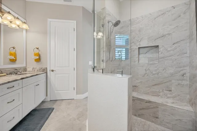 a bathroom with a granite countertop sink a toilet a mirror and shower