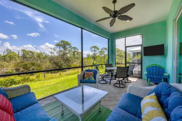 a living room with furniture floor to ceiling window and a ceiling fan