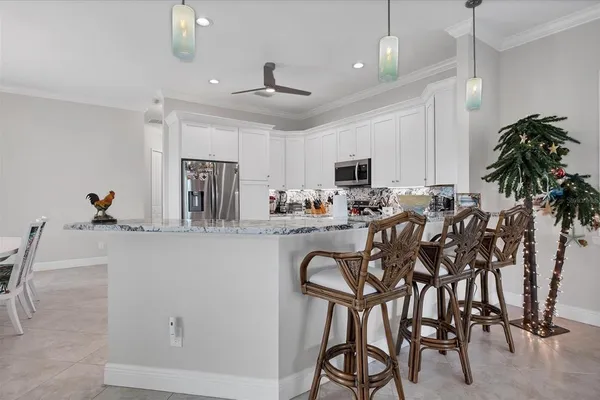a kitchen with stainless steel appliances a table chairs refrigerator and microwave