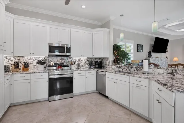 a kitchen with kitchen island granite countertop white cabinets and stainless steel appliances