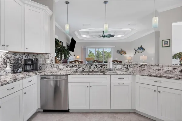 a kitchen with white cabinets and chandelier