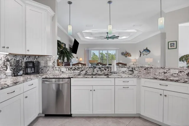a kitchen with white cabinets and chandelier