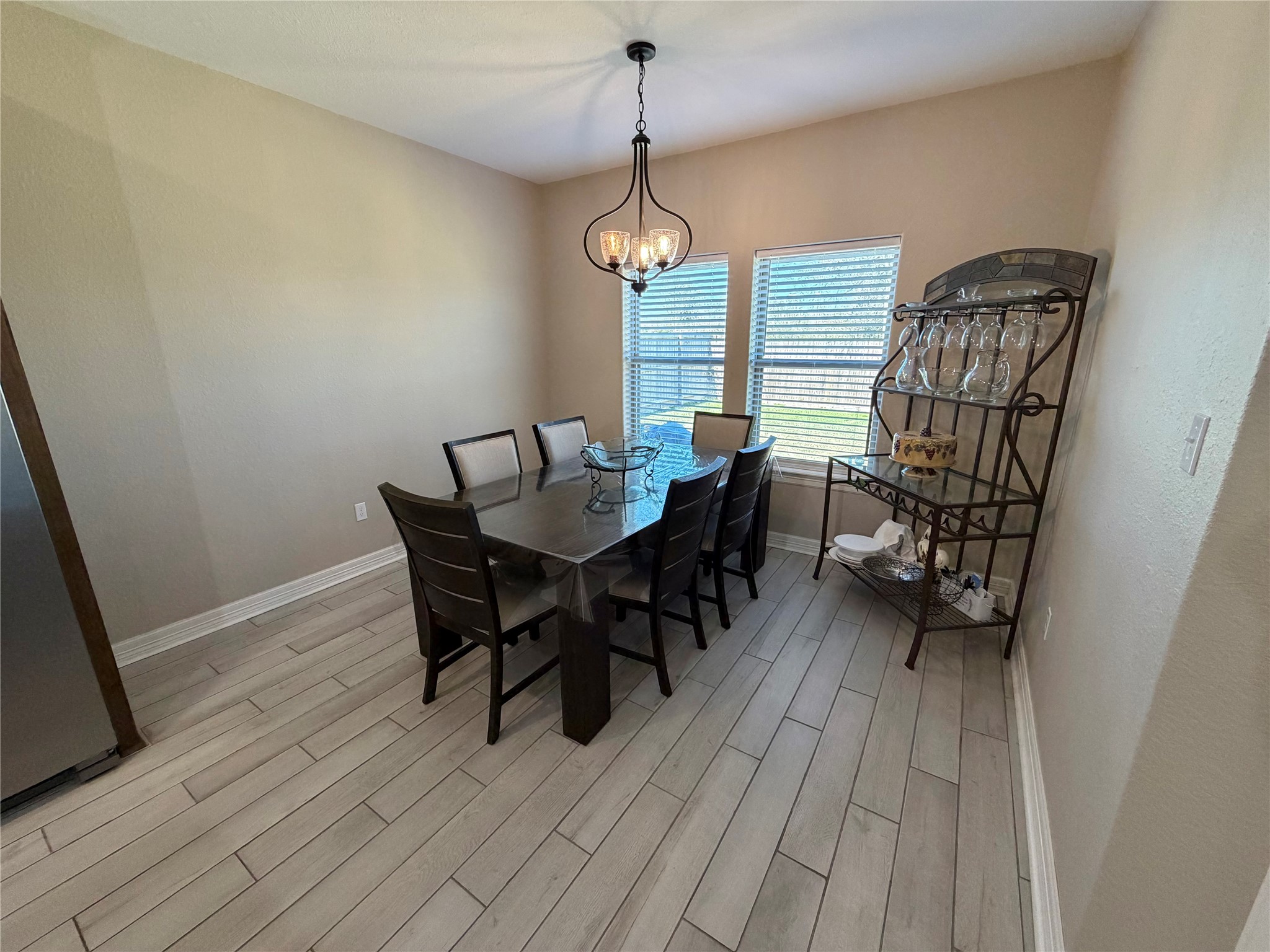 216 Shannon Street Angleton, TX 77515 - Photo 11 of 26 a dining room with wooden floor a chandelier a wooden table and chairs