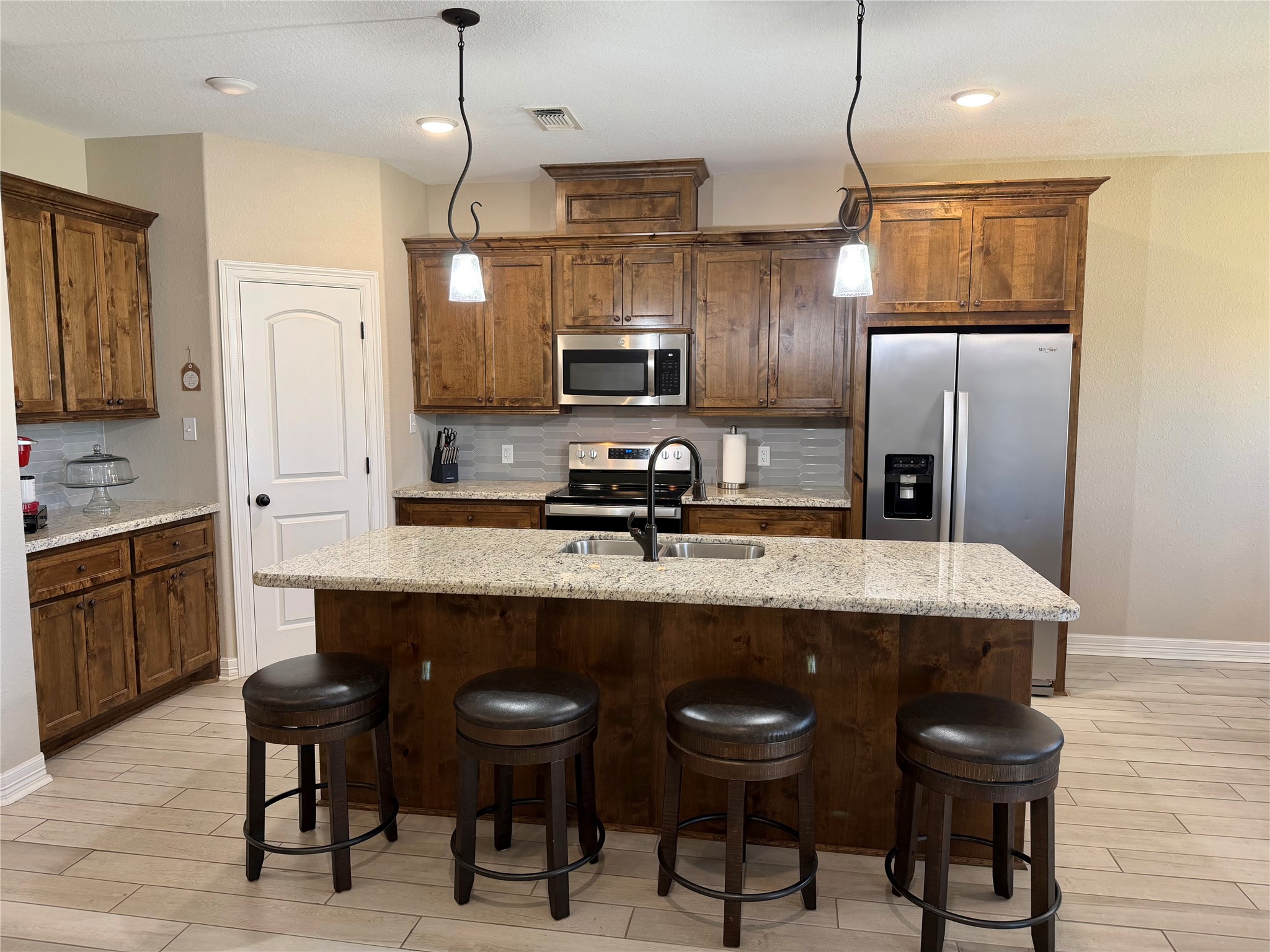 216 Shannon Street Angleton, TX 77515 - Photo 4 of 26 a kitchen with stainless steel appliances granite countertop a sink refrigerator and cabinets