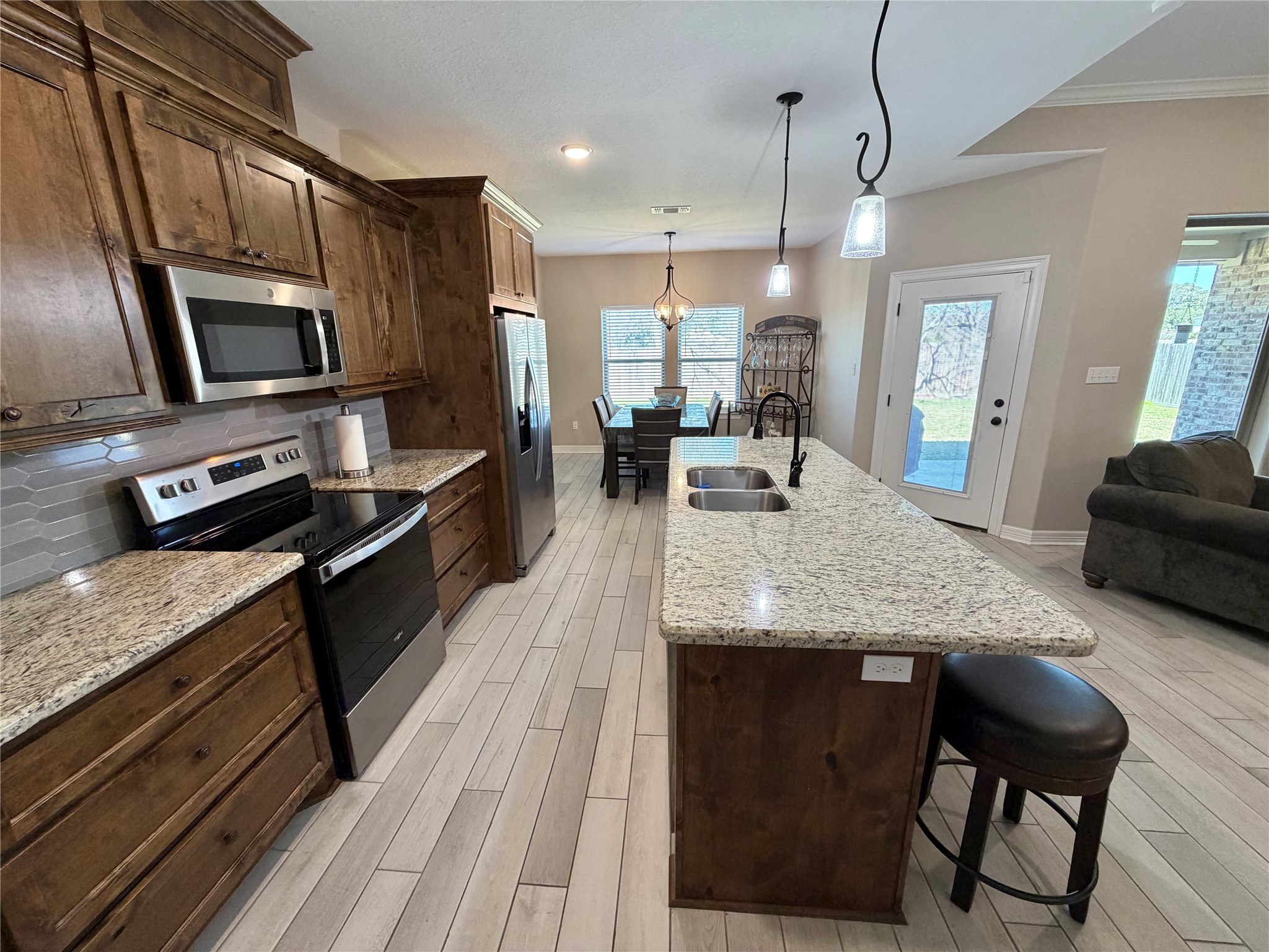 216 Shannon Street Angleton, TX 77515 - Photo 6 of 26 a kitchen with stainless steel appliances granite countertop wooden cabinets a stove top oven a sink and dishwasher