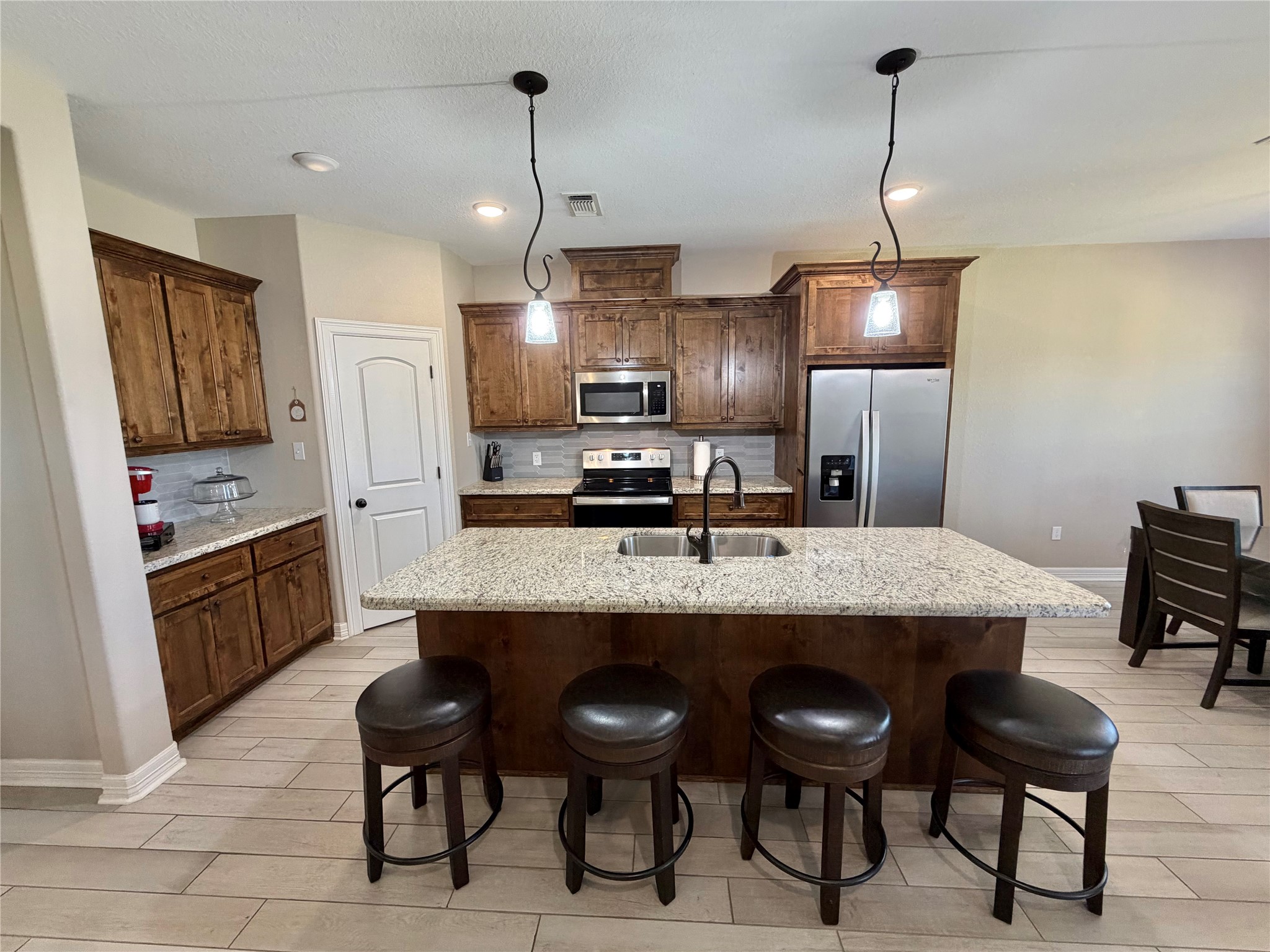 216 Shannon Street Angleton, TX 77515 - Photo 7 of 26 a large kitchen with a table chairs refrigerator and cabinets