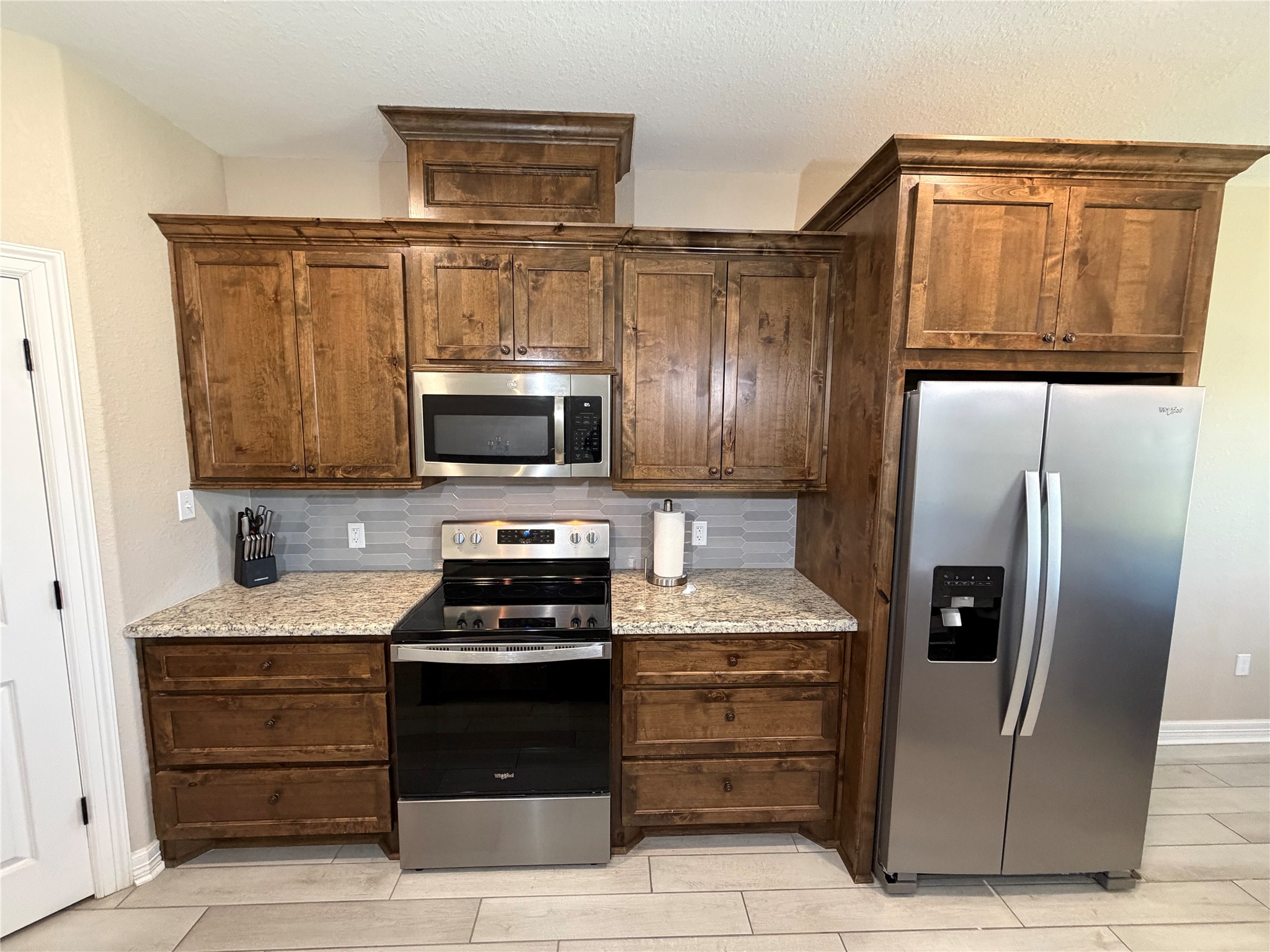 216 Shannon Street Angleton, TX 77515 - Photo 8 of 26 a kitchen with stainless steel appliances kitchen island granite countertop a refrigerator stove and microwave