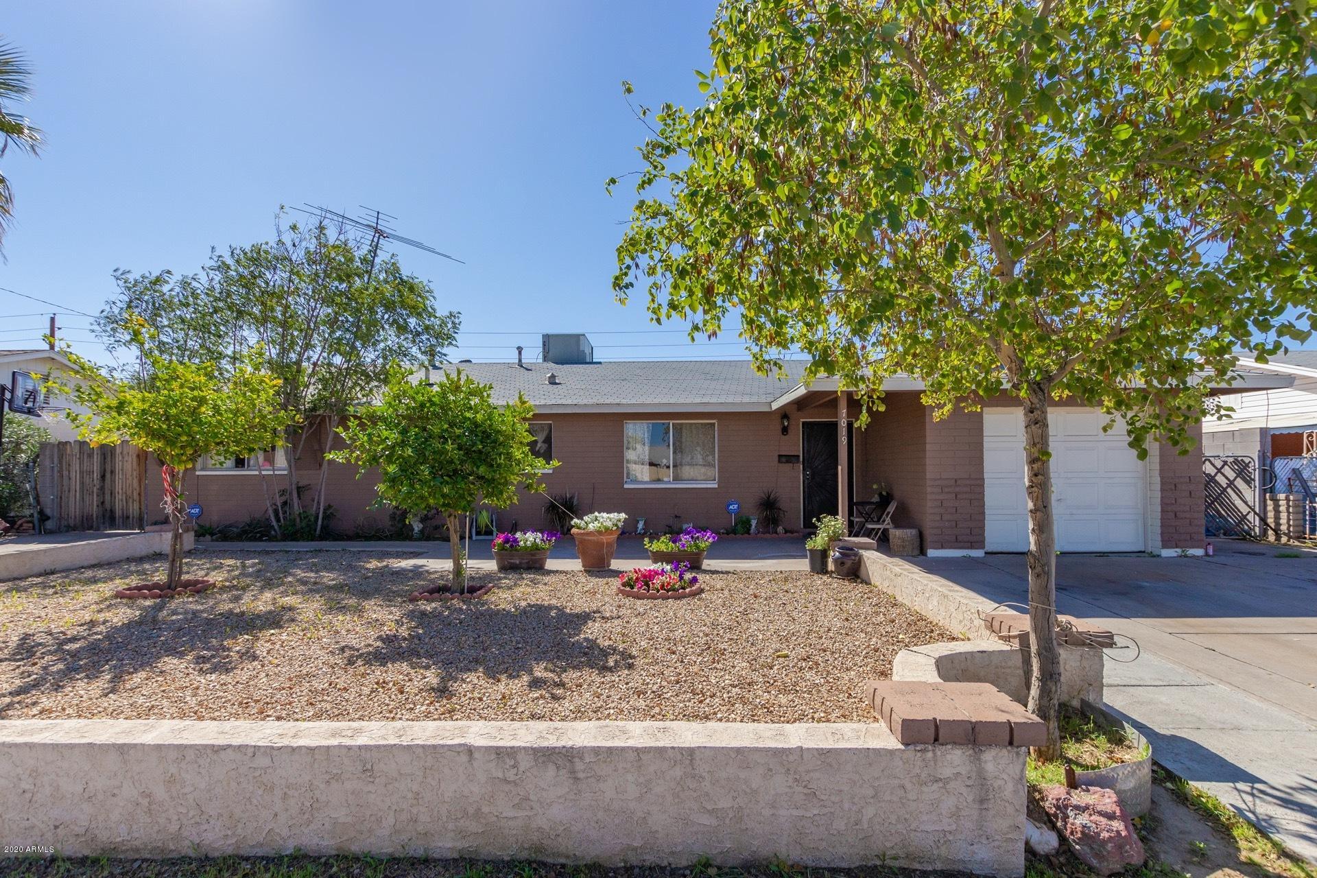 7019 West Camelback Road Phoenix, AZ 85033 - Photo 1 of 25 a front view of a house with garden and trees