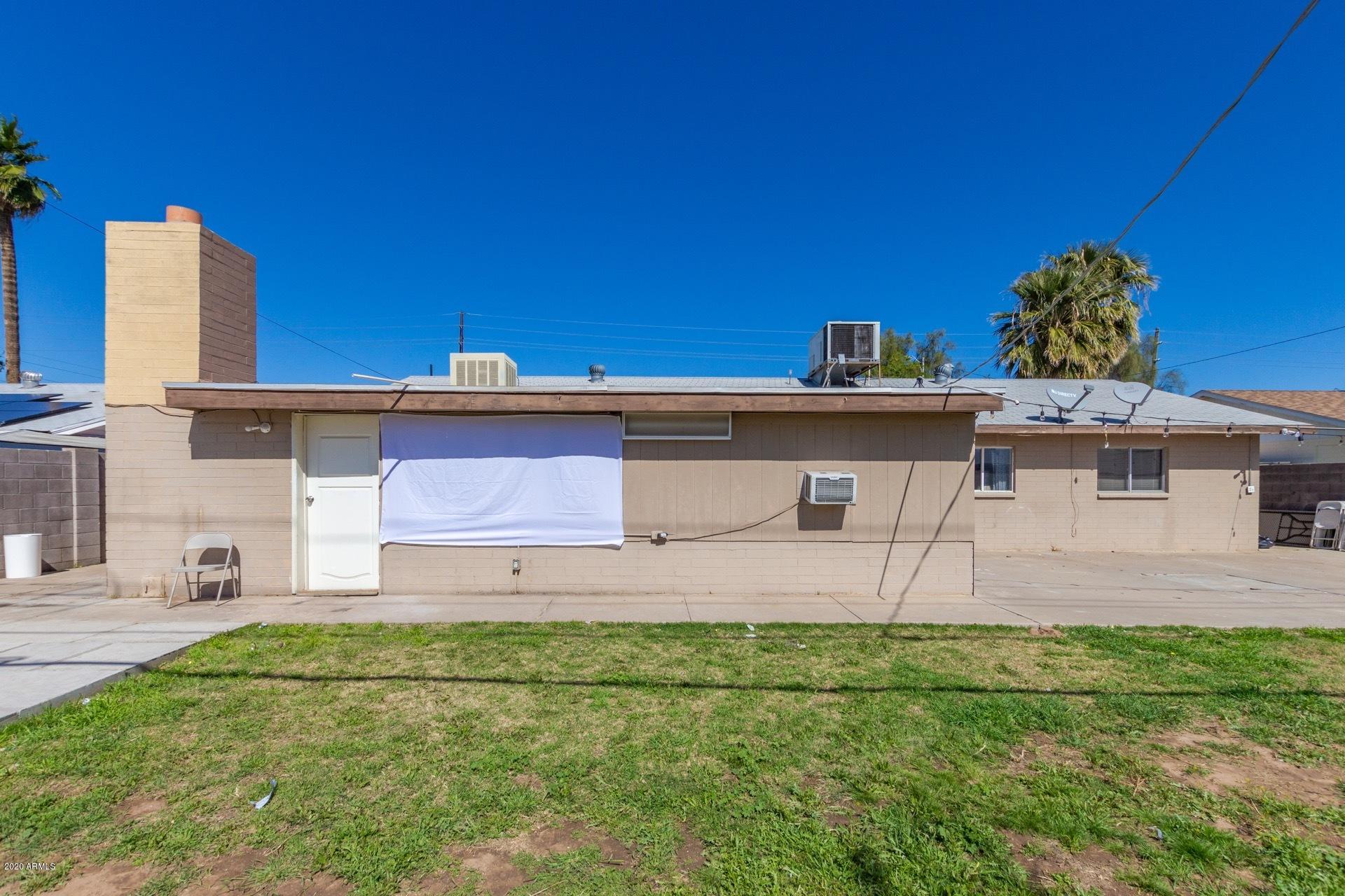 7019 West Camelback Road Phoenix, AZ 85033 - Photo 24 of 25 a front view of a house with a yard and garage