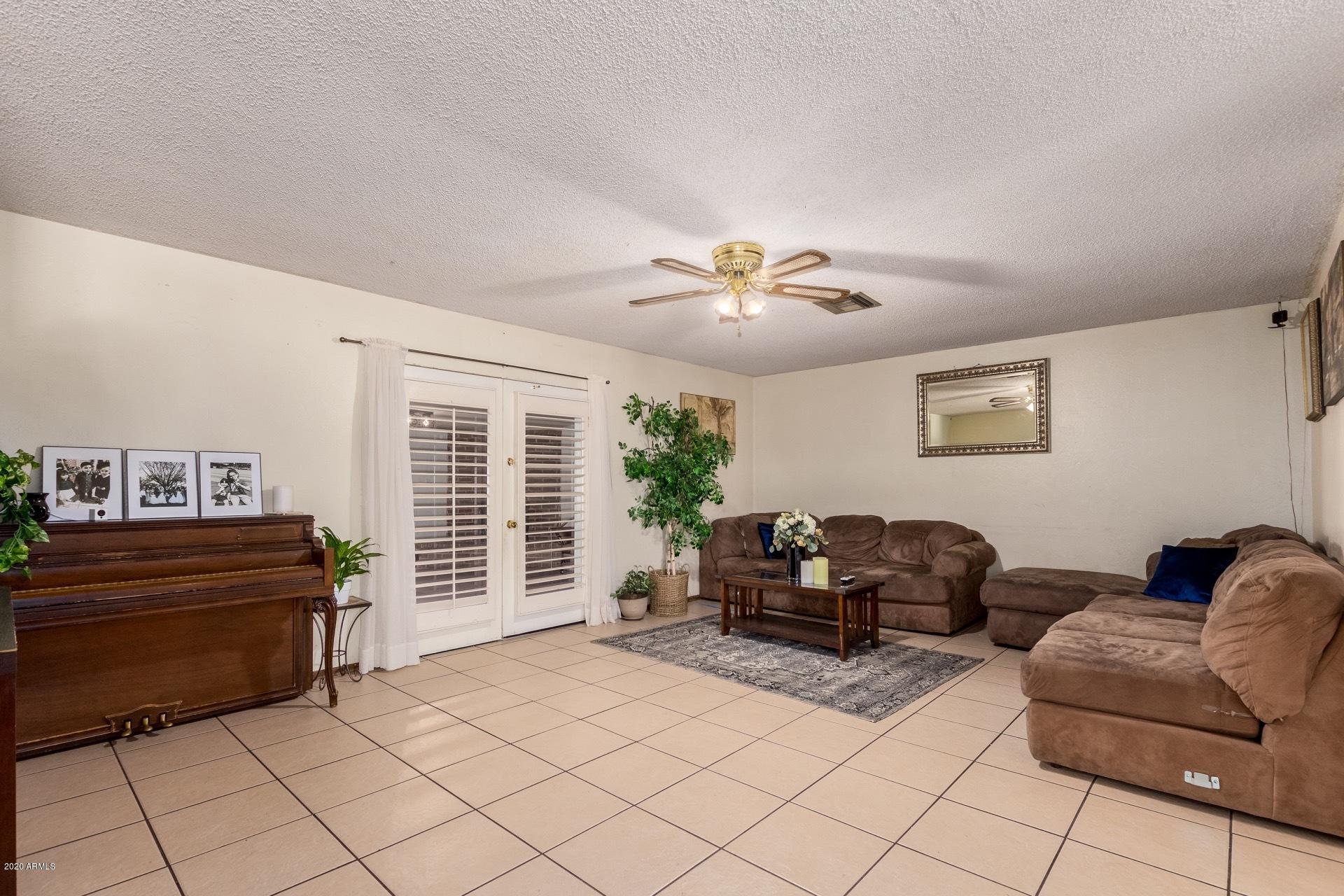 7019 West Camelback Road Phoenix, AZ 85033 - Photo 3 of 25 a living room with furniture and a chandelier