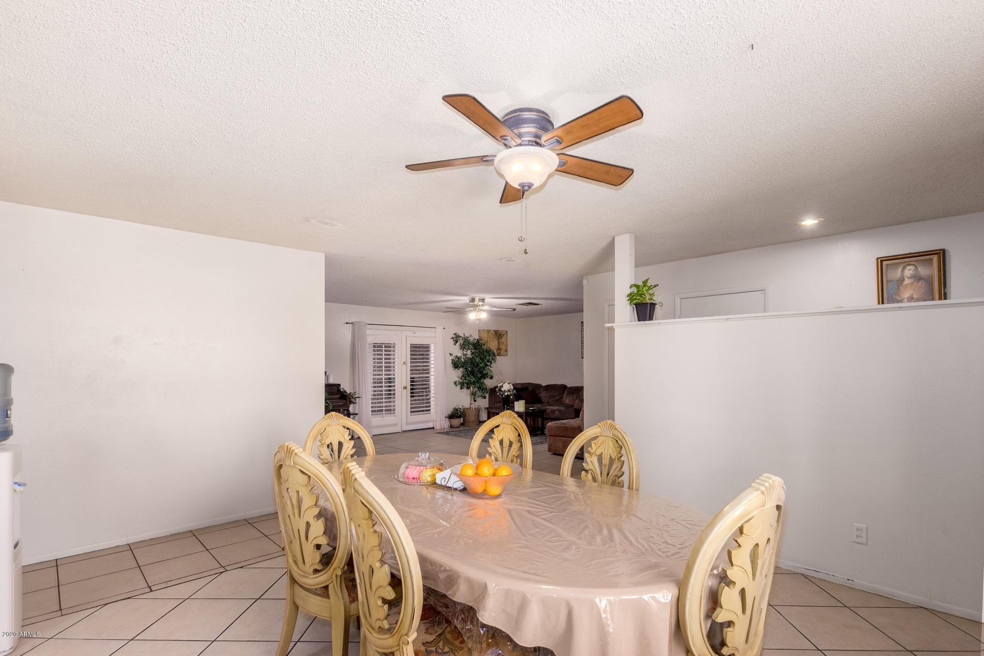 7019 West Camelback Road Phoenix, AZ 85033 - Photo 5 of 25 a dining room with furniture a window and wooden floor