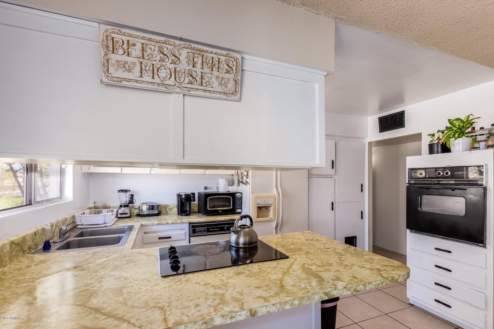 7019 West Camelback Road Phoenix, AZ 85033 - Photo 6 of 25 a kitchen with kitchen island sink stove and cabinets