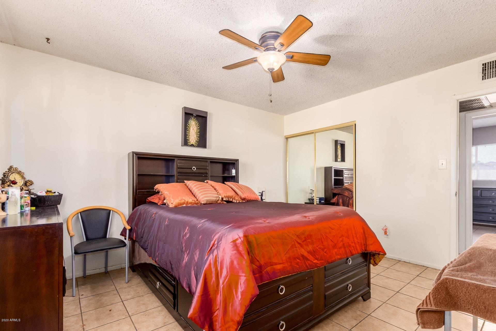 7019 West Camelback Road Phoenix, AZ 85033 - Photo 8 of 25 a bedroom with a bed and a chandelier
