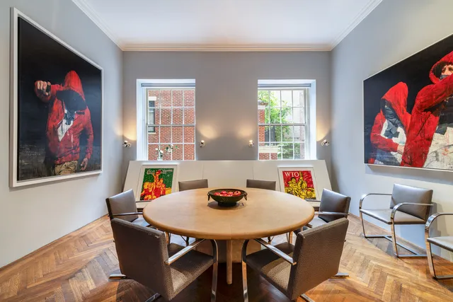 a view of a dining room with furniture a rug and wooden floor