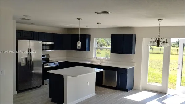 a kitchen with a sink a counter top space and stainless steel appliances