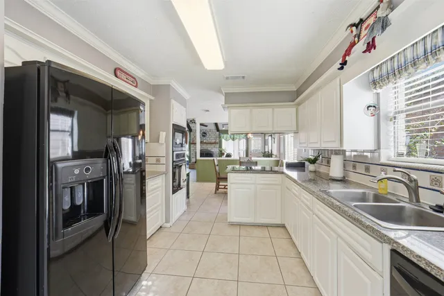 a kitchen with stainless steel appliances granite countertop a refrigerator a stove and a sink with wooden cabinets