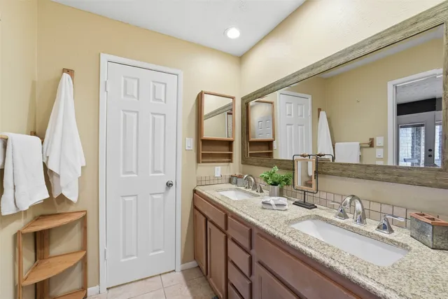 a bedroom with a large bed and dresser with mirror