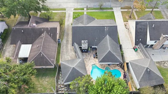 an aerial view of residential houses with outdoor space and swimming pool