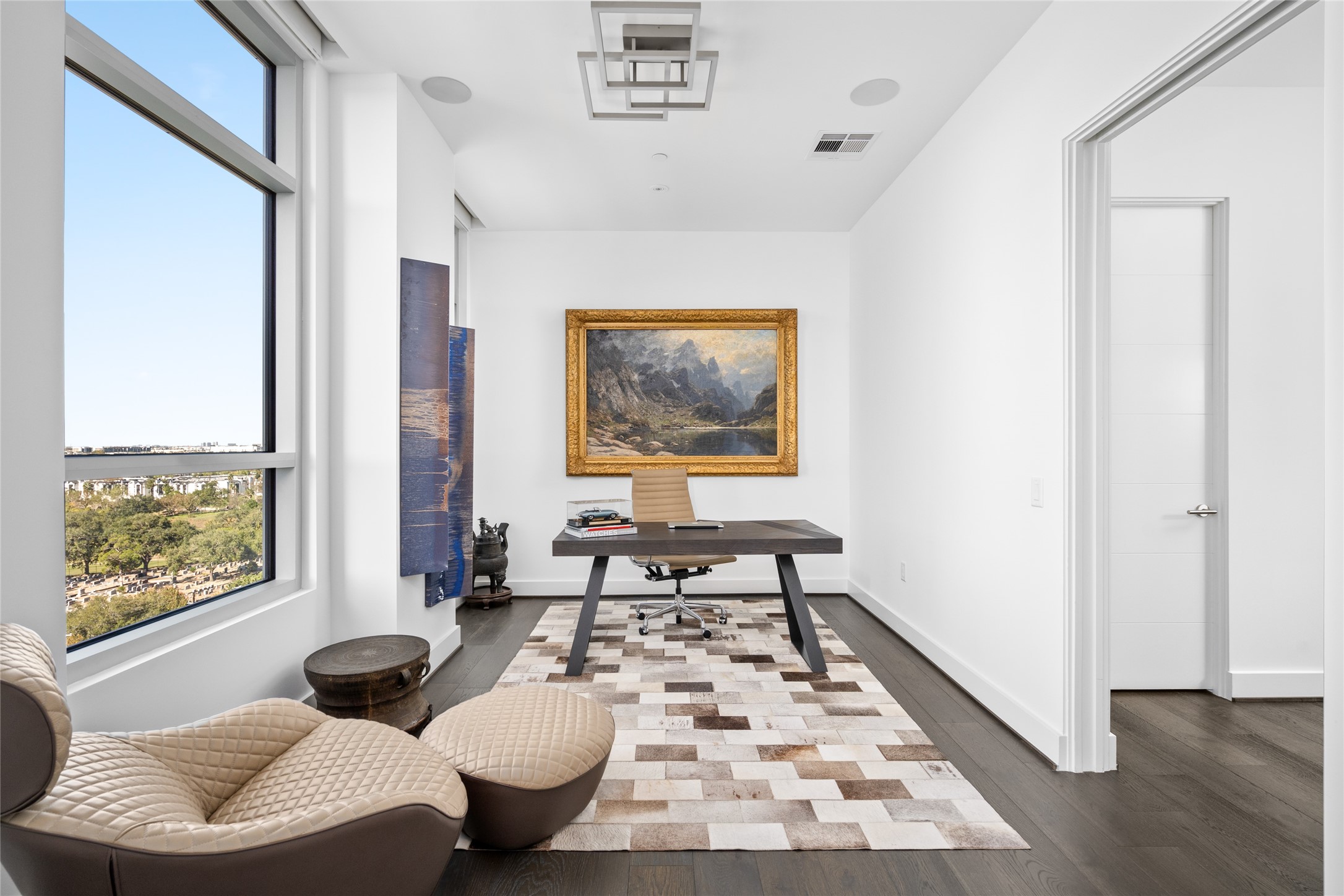3331 D'Amico Street, Unit 904 Houston, TX 77019 - Photo 14 of 21 Located just off the primary bedroom, the study features elegant hardwood floors, an ET2 Traverse flush-mount light fixture, integrated Savant surround sound, and expansive windows that offer stunning views, creating an inspiring and serene workspace.