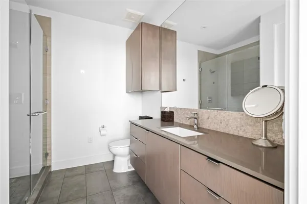 a bathroom with a sink a toilet and a mirror