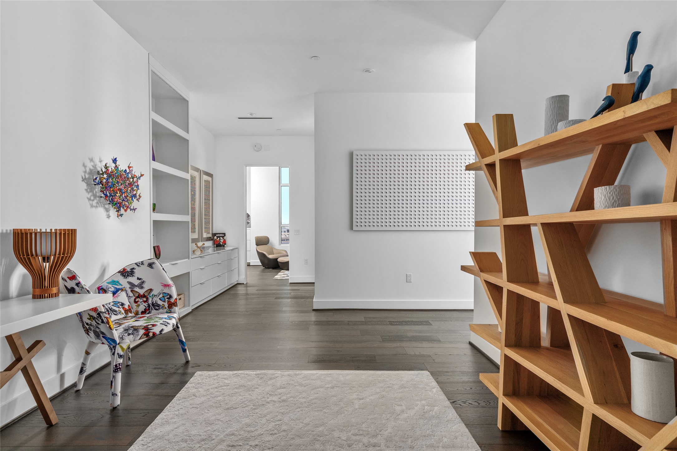 3331 D'Amico Street, Unit 904 Houston, TX 77019 - Photo 9 of 21 Featuring built-in shelves and storage, as well as large gallery walls perfect for showcasing art, the foyer creates a sophisticated transition space that separates the living and dining areas from the primary and secondary bedrooms, blending functionality with refined design.