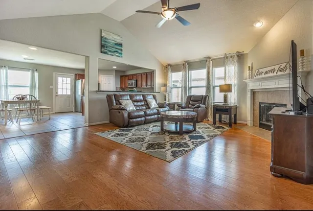 a living room with fireplace furniture and a wooden floor