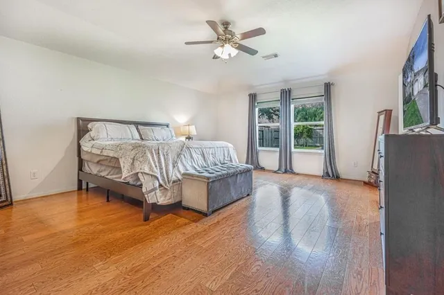 a spacious bedroom with a bed and a chandelier