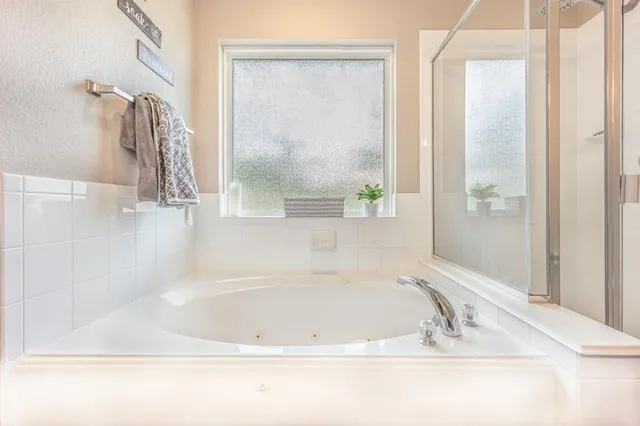 a white bath tub sitting next to a shower