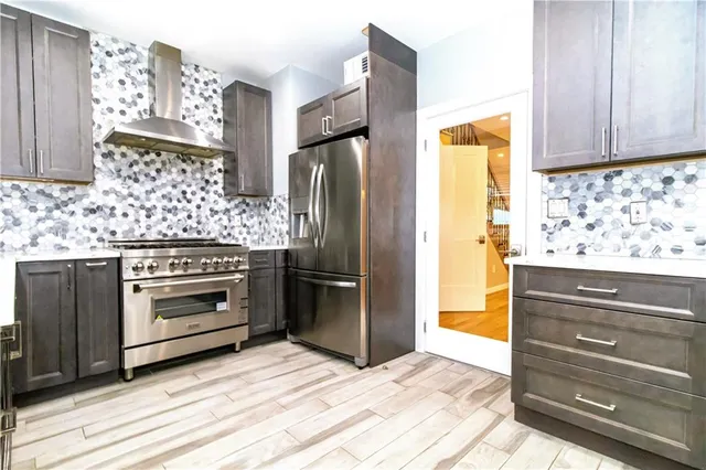 a kitchen with granite countertop a refrigerator and a stove top oven