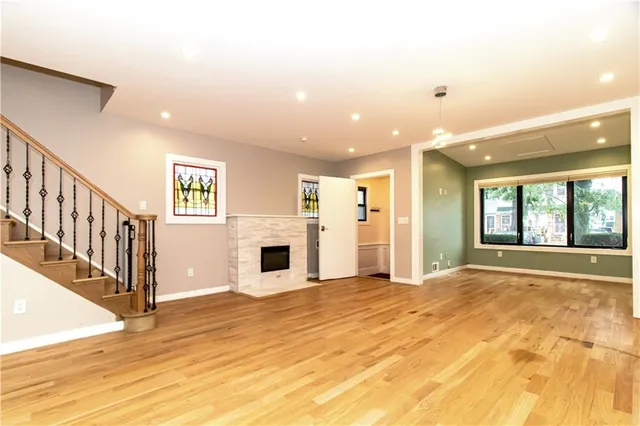 a view of staircase with lots of frames on wall and wooden floor